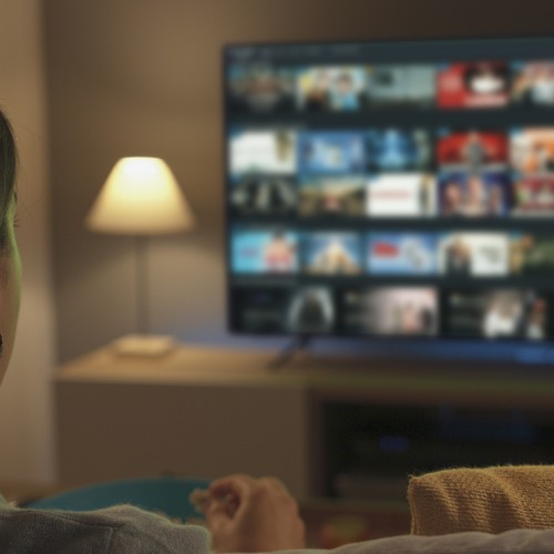 young-woman-watching-video-on-demand-on-her-tv.jpg_s1024x1024wisk20cno6ryHYhFMUcpSM53WZVZWwjXqJHB2vTuZ631utYPDI